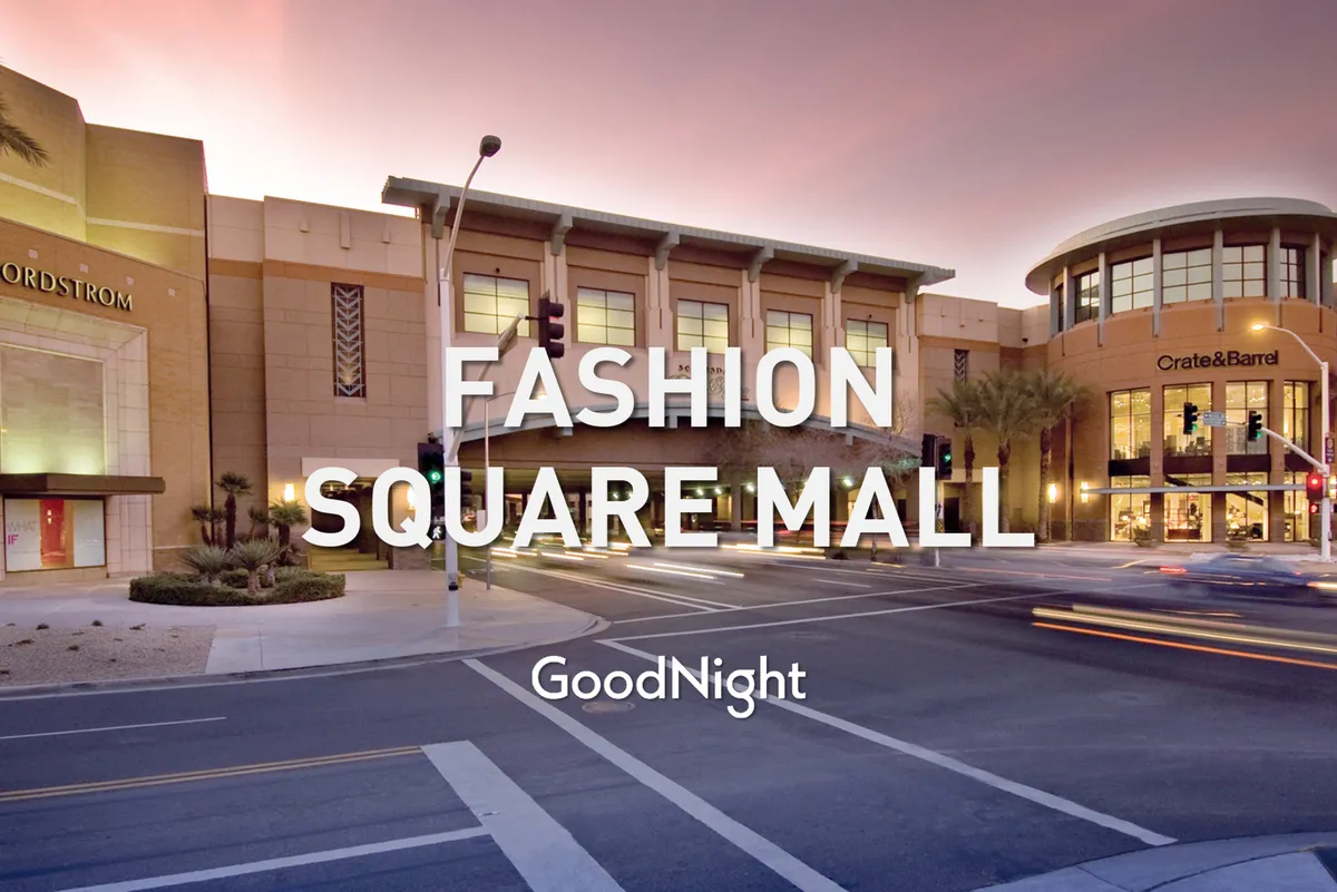 A dynamic exterior view of the Scottsdale Fashion Square entrance, featuring prominent storefronts like Nordstrom and Crate & Barrel, with people and cars adding to the bustling, cosmopolitan vibe.